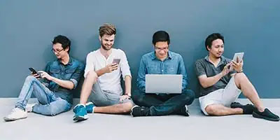 Four yong people on their phone, working a side hustle.