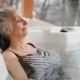 A woman enjoys a relaxing soak in a hot tub, a common project considered for the Medical Home Improvement Tax Deduction.